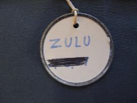 Circular label with metal outline tied to object