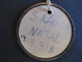 Circular label with metal outline tied to object