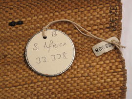 Circular label with metal outline tied to spoon/bag